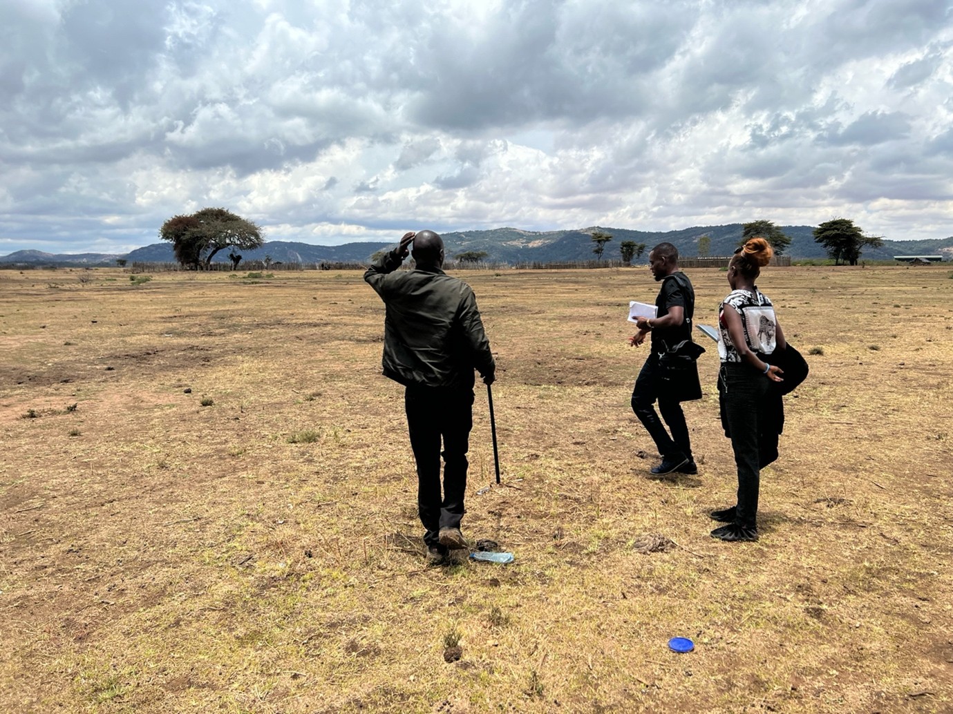 A group of men walk towards the horizon with their backs to the camera