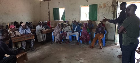 A group of Waldaa pastoralists sit in a room discussing planned changes to the National Land Policy