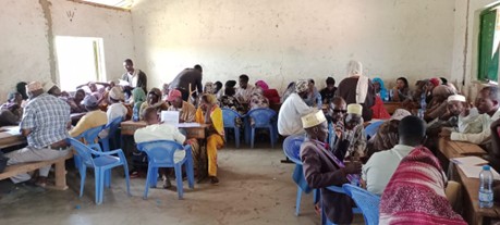 People from the Waldaa pastoralist group sit in a large room having a discussion