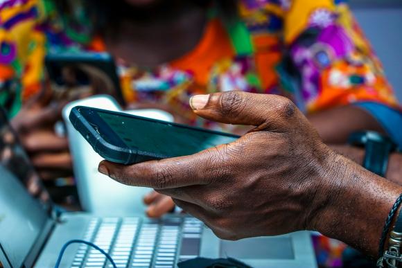 A close up of a man holding a mobile phone with a blurred background