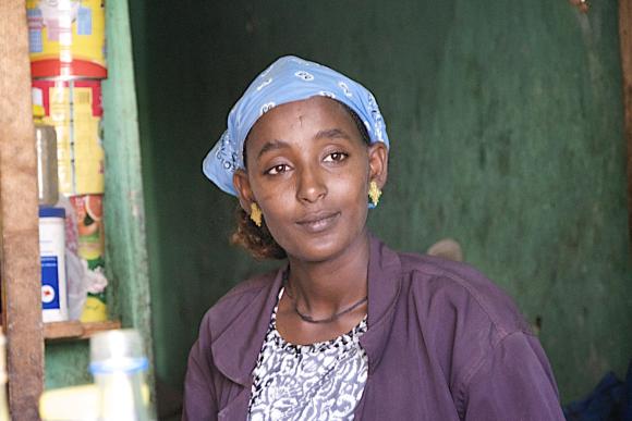 A woman smiling, looking beyond the frame