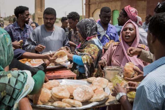 A woman sells bread at a busy market in Sudan