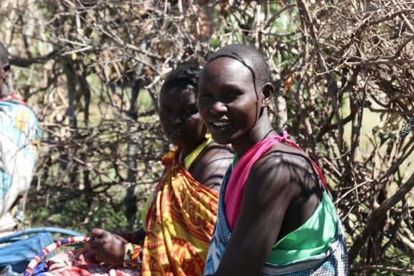 Two young women sitting together looking at the camera