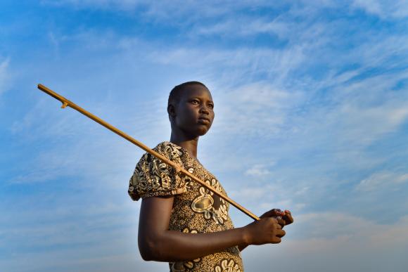 A woman stands in front of a blue sky