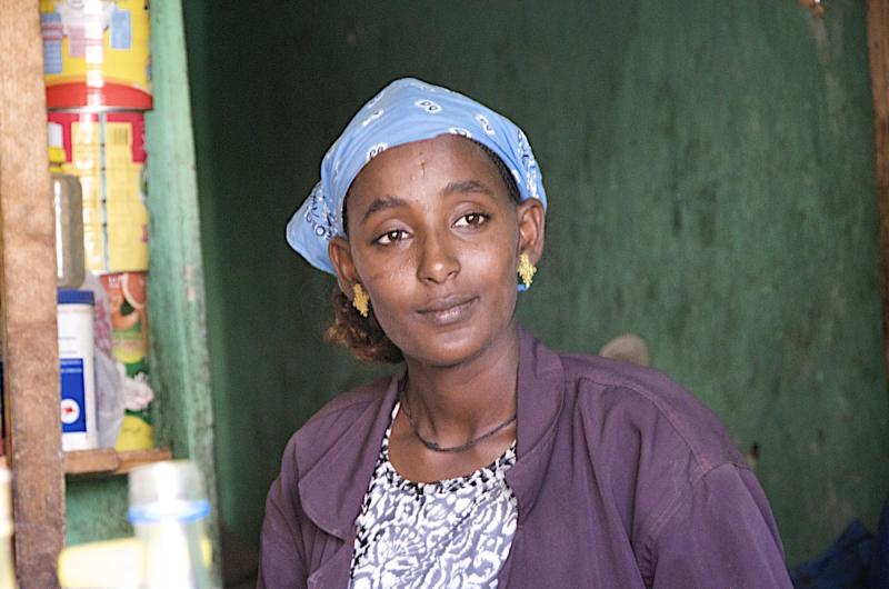 A woman smiling, looking beyond the frame