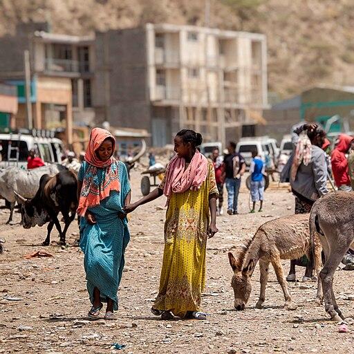Two smiling women talk as they walk towards the camera