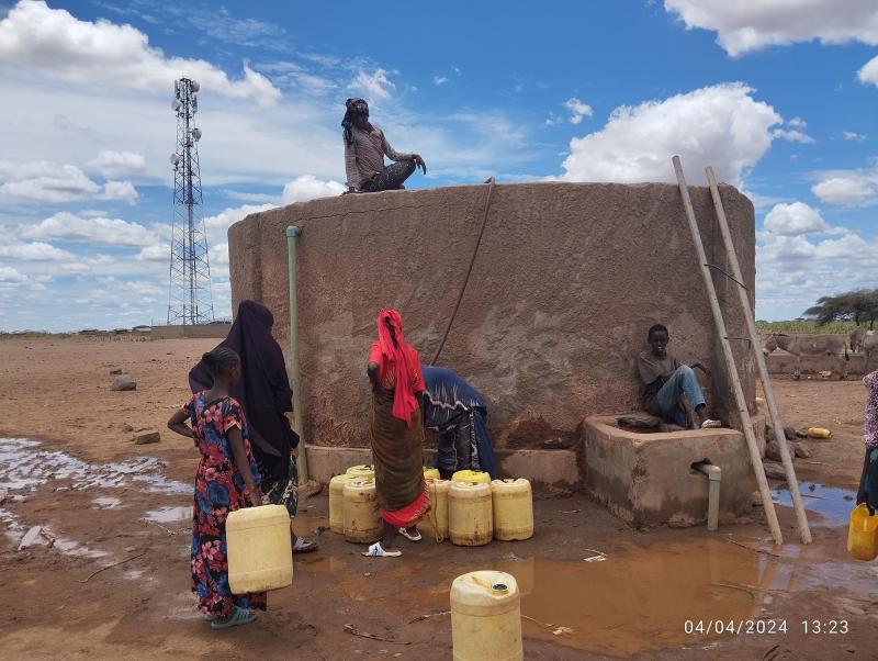 Community members around a water storage tank