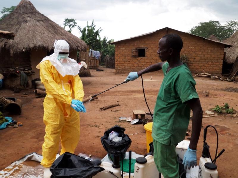 Two people disinfecting equipment and protective gear outside