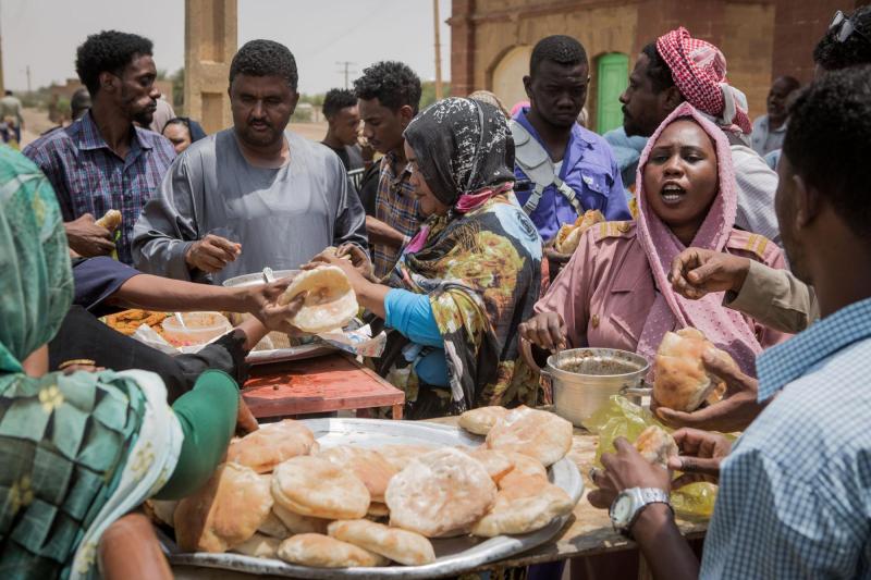A woman sells bread at a busy market in Sudan