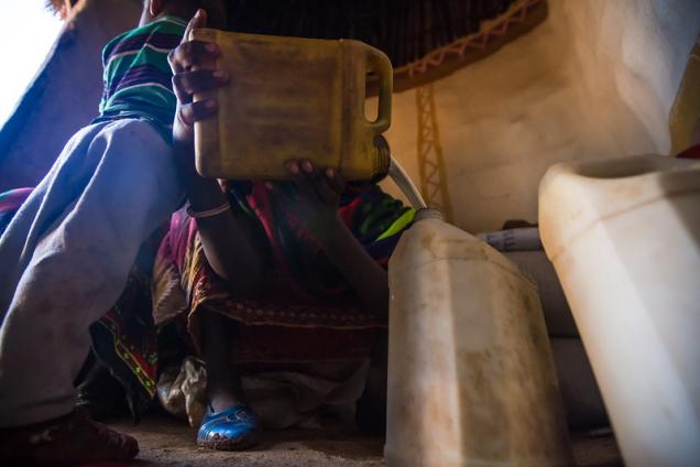 Dhaki Wako Baneta filters milk at a processing centre in Guradhera, Ethiopia. Pastoral communities collect and sell milk for profit.