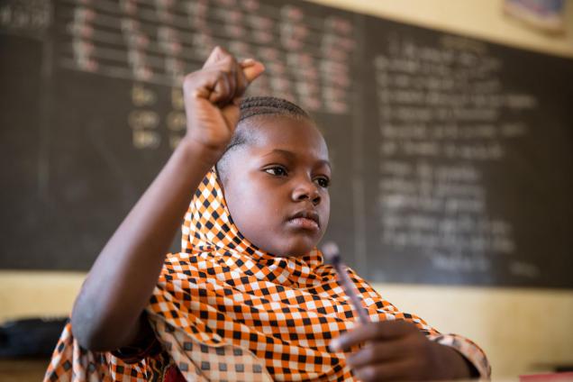 A girl raises her hand in a primary school class in Niamey, Niger.