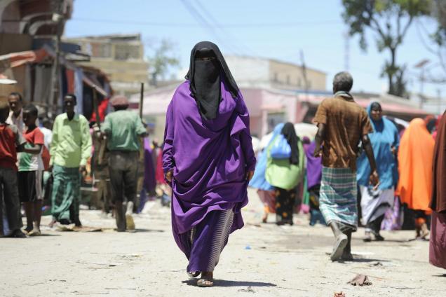 A Somali woman walks down the street in Mogadishu's Hamar Weyne market, ahead of the Eid al-Adha holiday.