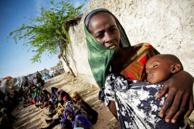 A Somali woman holds a malnourished child, waiting for medical assistance from the African Union Mission in Somalia (AMISOM). Photo ID 480269. 16/07/2011. Mogadishu, Somalia. UN Photo/Stuart. (CC BY-NC-ND 2.0)