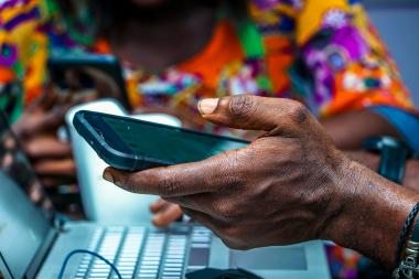 A close up of a man holding a mobile phone with a blurred background