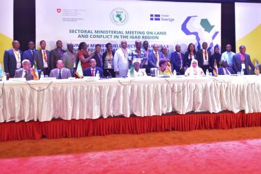 A group of people stand on the stage in front of a banner at the IGAD conference