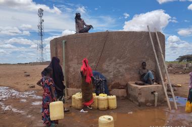 Community members around a water storage tank