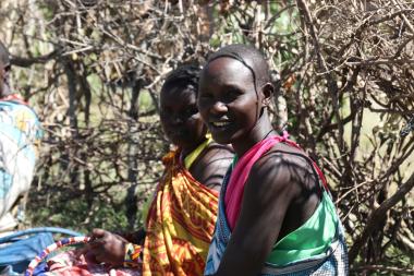 Two young women sitting together looking at the camera