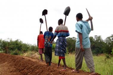 Villagers going home after building an embankment in anticipation of flooding on the River Juba, Somalia. - Mercy Corps